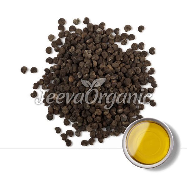 A pile of black seeds alongside a small dish of golden oil, with a "Jeeva Organic" logo in the background.