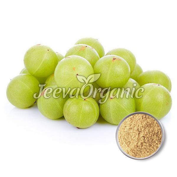 A cluster of fresh green amla (Indian gooseberries) with a bowl of amla powder in the corner, suggesting health benefits and culinary uses.