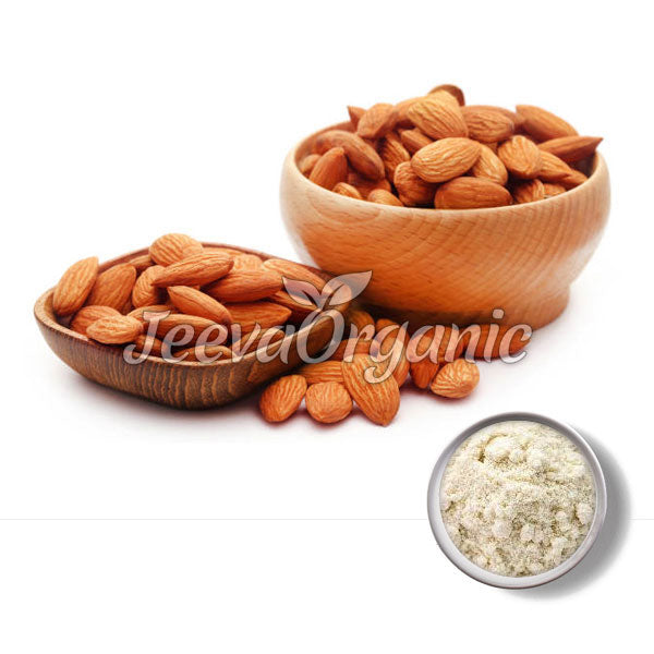 Two wooden bowls filled with raw almonds, with some almonds scattered around, alongside a small bowl of almond flour.