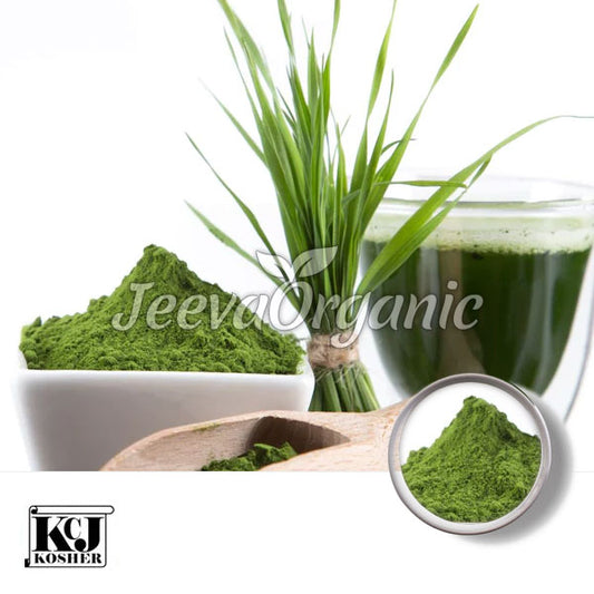 Image of vibrant green powder in a bowl and wooden scoop, beside fresh grass and a glass of green juice, labeled "Jeeva Organic."